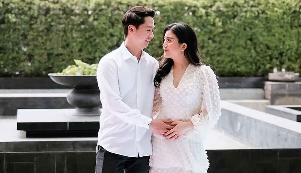 Sedangkan calon ayah dan ibu,  Valencia dan Kevin tampak kompak mengenakan putih-putih. Anak pengusaha Hari Tanoesoedibyo anggun mengenakan dress layer dengan pendek selutut. Sedangkan pemain ganda putra bulutangkis Indonesia itu bergaya kasual dengan kemeja putih dan celana hitam. [Instagram/valenciatanoe]