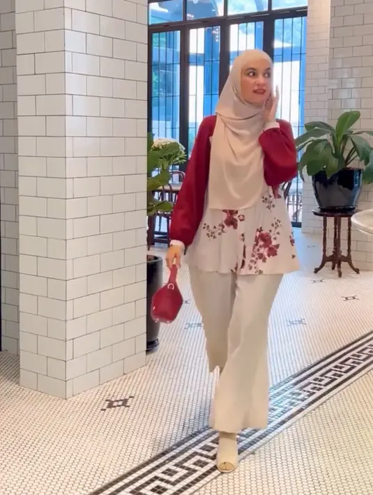 Shireen Sungkar mengenakan atasan kemeja lengan merah dengan corak bunga warna serasi dipadukan bawahan warna putih celana flare serta kerudung warna putih. [@shireensungkar]