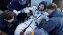 Regu penyelamat badan antariksa Rusia membantu awak Stasiun Luar Angkasa Takuya Onishi dari Jepang setelah keluar dari Kapsul Soyuz MS yang berhasil mendarat di  Dzhezkazgan, Kazakhstan (30/10). (Reuters/Dmitri Lovetsky)