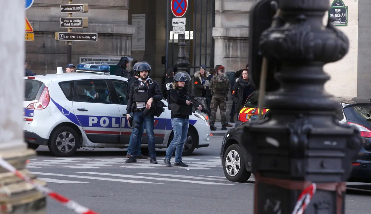 Petugas berjaga-jaga di sekitar Museum Louvre usai terjadi penyerangan, Perancis, Jumat (3/2). Tersangka dilaporkan membawa dua bilah parang dan dikabarkan mengalami luka serius akibat tembakan yang dilepaskan oleh tentara. (AP Photo/Thibault Camus)