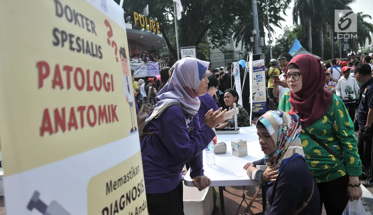 Warga berkonsultasi dengan dokter sebelum diperiksa tensi saat car free day di kawasan Bundaran HI, Jakarta, Minggu (18/11). Kegiatan periksa tensi secara gratis ini dalam rangka memperingati Hari Patologi Internasional. (Merdeka.com/Iqbal S. Nugroho)