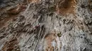 Peserta berusaha memanjat tebing dalam Festival Mendaki tahunan 2019 di pulau Kalymnos, Yunani (4/10/2019). Pemandangan menakjubkan dan cuaca bagus menjadikan pulau ini sebagai tujuan utama bagi pemanjat dari semua tingkatan dengan lebih dari 2500 rute pendakian. (AFP Photo/Aris Messinis)