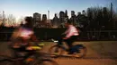 Warga bermain sepeda setelah matahari terbenam saat menikmati taman Brooklyn di New York City (21/2). Cuaca New York akan berubah kembali ke musim dingin dengan suhu yang diperkirakan 30 derajat. (AFP Photo/Spencer Platt)