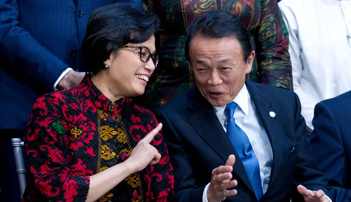Menteri Keuangan Sri Mulyani Indrawati berbincang dengan dengan Menteri Keuangan Jepang, Taro Aso saat akan sesi foto International Monetary Fund (IMF) Governors di rapat musim semi World Bank/IMF, Washington, (22/4). (AP Photo/Jose Luis Magana)