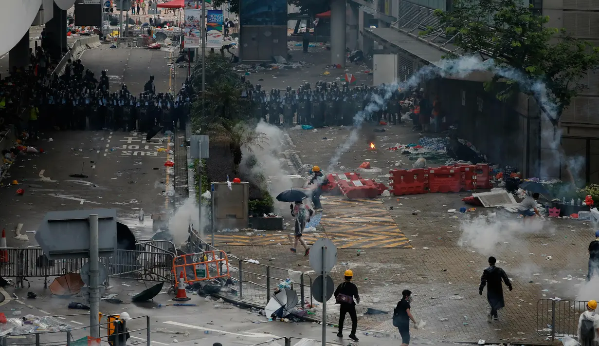 Polisi anti huru hara menembakkan gas air mata ke arah demonstran di luar gedung Dewan Legislatif, Hong Kong, Rabu (12/6/2019). Polisi Hong Kong telah menggunakan gas air mata ke arah ribuan demonstran yang menentang RUU ekstradisi yang sangat kontroversial. (AP Photo/Vincent Yu)