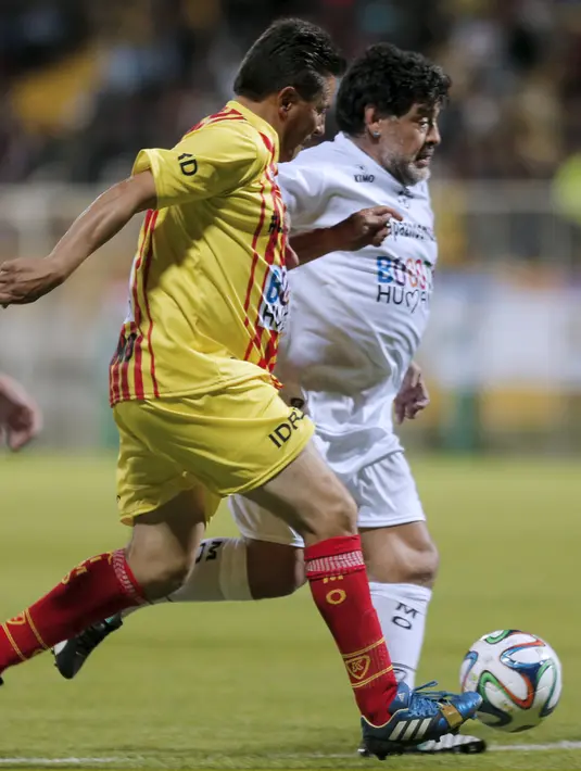 Mantan Penyerang Argentina, Diego Armando Maradona berusaha membawa bola melewati pemain pada laga amal untuk Perdamaian di Techo stadion, Bogota, Kolumbia (10/42015). (REUTERS/John Vizcaino)