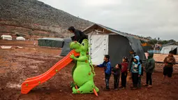 Anak-anak mengantre untuk bermain perosotan turun di sebuah kamp untuk warga Suriah yang kebanjiran di dekat desa Killi di utara provinsi Idlib barat laut (5/12/2019). (AFP Photo/Aaref Watad)
