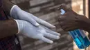 Seorang pelajar mendisinfeksi tangannya sebelum memasuki lokasi ujian kelayakan yang digelar untuk menyeleksi peserta program sarjana medis di Srinagar, ibu kota musim panas Kashmir yang dikuasai India, pada 13 September 2020. (Xinhua/Javed Dar)