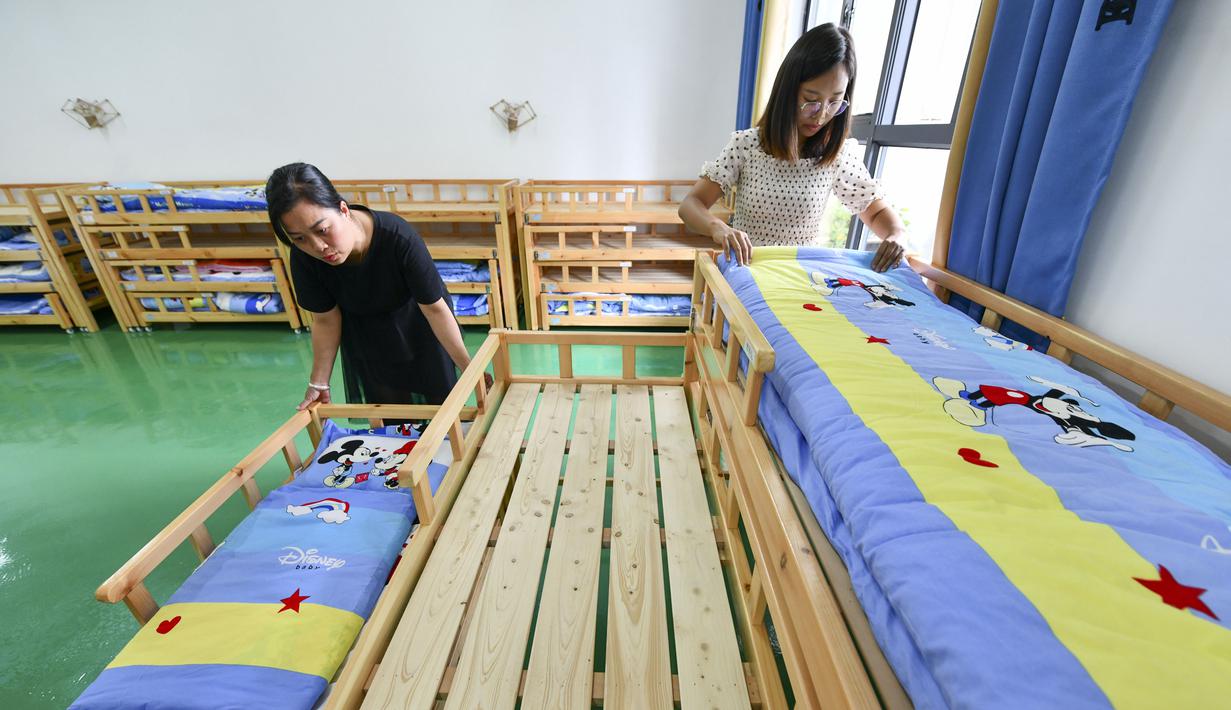 Sejumlah guru merapikan tempat tidur di taman kanak-kanak lokasi relokasi wilayah Sansui, Provinsi Guizhou, China, 30 Agustus 2020. Guizhou merelokasi 1,88 juta orang guna membantu anak-anak dari daerah-daerah miskin memiliki akses pendidikan yang lebih baik. (Xinhua/Yang Wenbin)