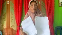 Suarni Pido, salah satu warga Desa Moutong saat menunjukan dokumen terkait dengan kepala desa (Arfandi Ibrahim/Liputan6.com)