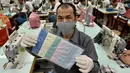 Seorang narapidana menunjukkan masker di ruang kerja menjahit di Penjara Taipei di Kota Taoyuan, Taiwan utara (10/3/2020). Taiwan berhasil mempertahankan jumlah kasus virus corona yang dikonfirmasi menjadi 45 dan satu kematian. (AFP/Sam Yeh)