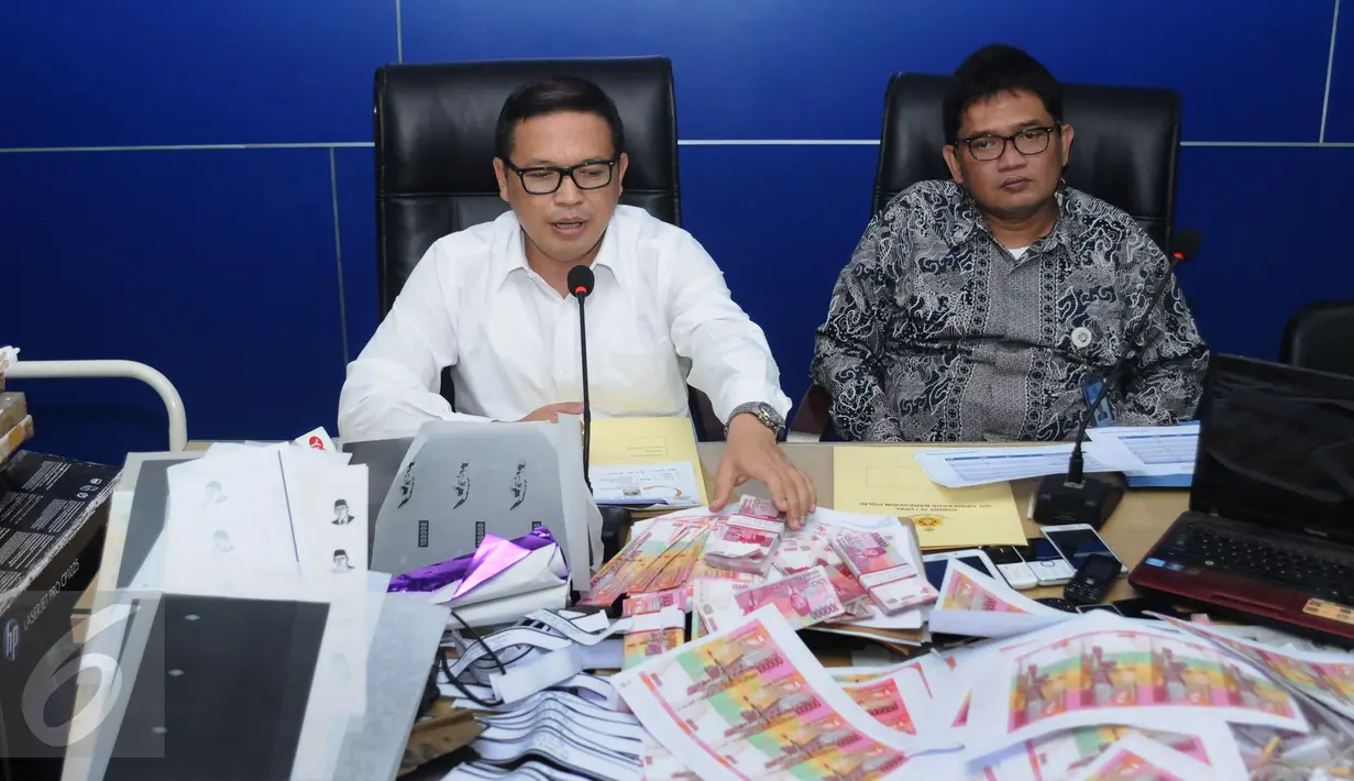 DirTipideksus Bareskrim Brigjen Agung Setya (kiri) memberi keterangan terkait pengungkapan peredaran uang palsu saat rilis di Bareskrim Mabes Polri, Gedung KKP, Jakarta, Senin (10/10). Empat tersangka diamankan. (Liputan6.com/Helmi Fithriansyah)