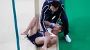 Seorang pelatih membantu atlet senam artistik Prancis Samir Ait Said setelah mengalami cedera pada babak kualifikasi Olimpiade Rio 2016 di Rio Olympic Arena, Brasil, Minggu (7/8). Samir gagal mendarat dan membuat kaki kirinya patah. (Thomas COEX/AFP)