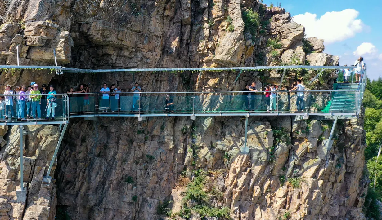 Wisatawan berjalan di atas jembatan kaca di kawasan wisata Jiulongwan di Wilayah Zhuozi, Ulanqab, Daerah Otonom Mongolia Dalam, China utara, pada 16 Agustus 2020. (Xinhua/Peng Yuan)