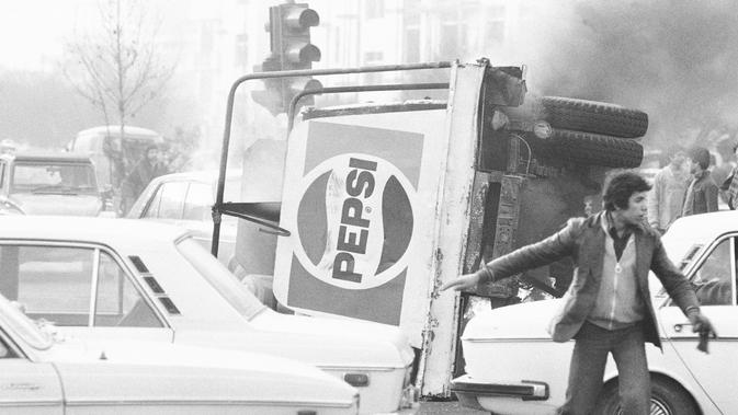Sebuah truk berlogo minuman ringan Pepsi terbakar selama kerusuhan di Teheran, Iran, 27 Desember 1978. Revolusi Iran disebut sebagai revolusi terbesar ketiga dalam sejarah dunia. (AP Photo, File)