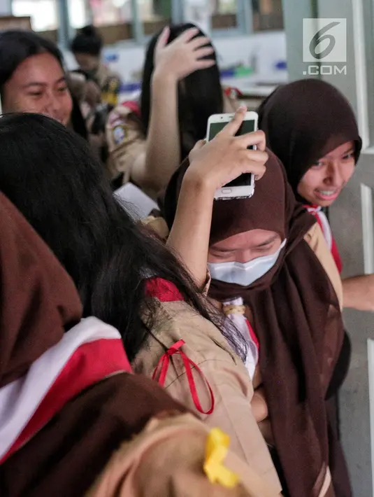 Sejumlah siswa berlarian menyelamatkan diri saat simulasi bencana di SMA Negeri 78 Jakarta, Rabu (23/1). Kegiatan itu untuk pengenalan kepada siswa-siswi dengan program siaga bencana berupa simulasi evakuasi gempa dan tsunami. (Liputan6.com/Faizal Fanani)