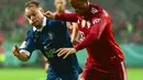 Gelandang Bayern Munchen, Leroy Sane membawa bola dari kawalan pemain Bremen SV, Mats Kaiser dalam laga putaran pertama DFB Pokal 2021-22 di Bremen, Jerman utara (25/8/2021). Munchen menang telak atas Bremen SV dengan skor 12-0. (AFP/Patrik Stollarz)