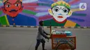 Soerang pedagang melintas di Flyover 'Gaplek' Martadinata yang dipercantik dengan lukisan mural di Tangerang Selatan, Jumat (9/4/2021). Seni mural ini untuk memperindah suasana jalan kota. (merdeka.com/Imam Buhori)