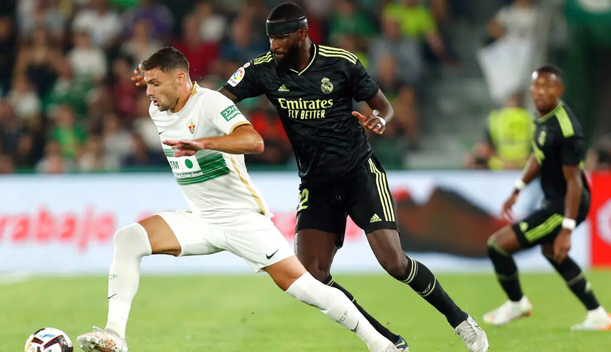 Pemain Real Madrid Antonio Rudiger (kanan) berebut bola dengan pemain Elche Lucas Boye pada pertandingan sepak bola La Liga Spanyol di Stadion Martinez Valero, Elche, Spanyol, 19 Oktober 2022. Real Madrid mengalahkan Elche dengan skor 3-0. (AP Photo/Alberto Saiz)