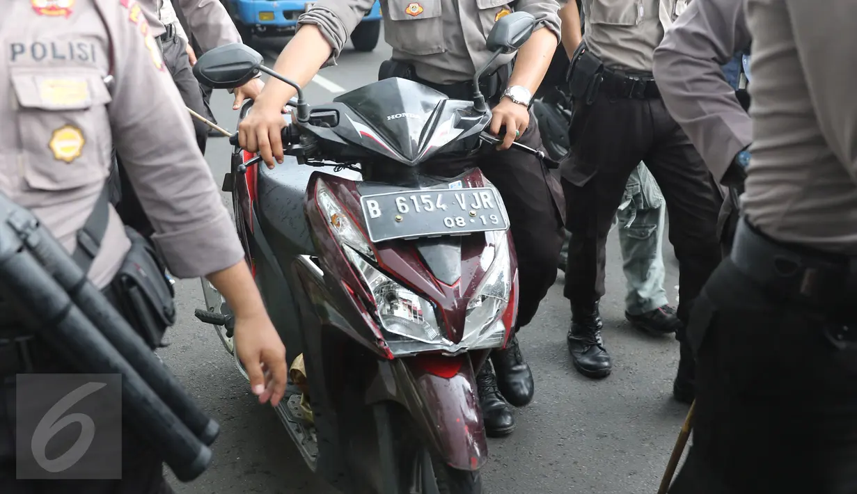 Petugas keamanan mengamankan sebuah sepeda motor di kawasan  dekat gedung TVRI Senayan, Jakarta, (22/3). Kawasan tersebut memang sedang terjadi unjukrasa sejumlah supir taksi. (Liputan6.com/Herman Zakharia)