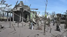 Rumah-rumah rusak yang diselimuti abu vulkanik erupsi Gunung Semeru terlihat di Desa Curah Kobokan, Lumajang, Jawa Timur, Selasa (7/12/2021). Desa yang berada sekitar 15 km dari Lereng Semeru tersebut menjadi desa paling parah yang terkena dampak letusan Gunung Semeru. (ADEK BERRY/AFP)