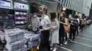 Orang-orang mengantre untuk edisi terakhir Apple Daily di stan surat kabar di sebuah jalan pusat kota di Hong Kong, Kamis (24/6/2021). Ratusan orang mengantre pada Kamis dini hari untuk membeli edisi cetak terakhir surat kabar pro-demokrasi Hong Kong, Apple Daily. ( AP Photo/Vincent Yu)