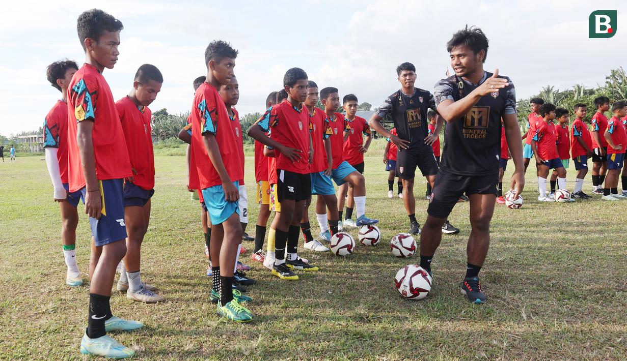 Ilham Udin Armaiyn memberi instruksi kepada anak-anak yang akan melakukan latihan passing saat coaching clinic di Kota Sofifi, Maluku Utara, Senin (14/8/2023) sore hari WIT. . (Bola.com/Okie Prabhowo)
