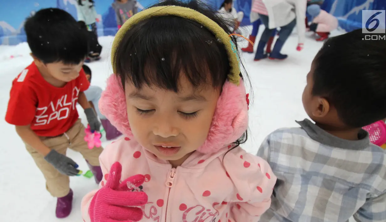 Ekspresi seorang anak saat bermain dengan sajlu dan es di Snow Village pada salah satu pusat perbelanjaan di kawasan Tangerang Selatan, Banten, Senin (17/12). (Merdeka.com/Arie Basuki)