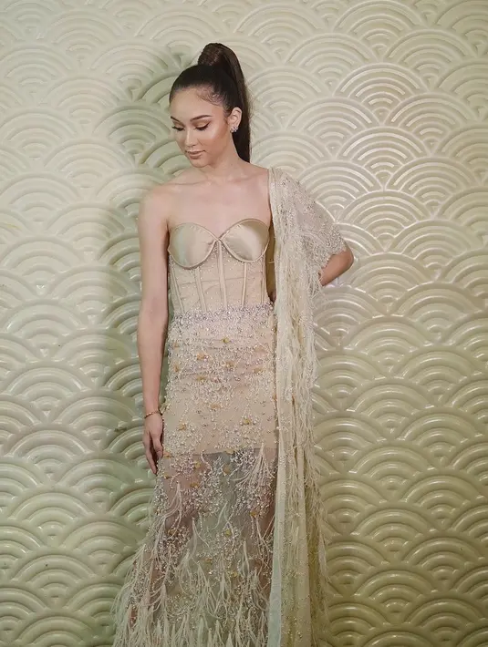 Ketika menghadiri sebuah acara, Yasmin Napper terlihat memesona dengan gaya vintage. Kali ini ia tampil dengan sleeveless dress berwarna krem dan makeup memukau. Rambut yang dikuncir itu membuatnya tampak mirip Ariana Grande. (Liputan6.com/IG/@rhay_david)