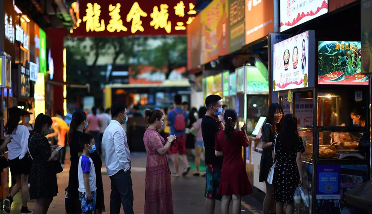 Warga mengantre untuk membeli makanan di pedagang kaki lima di Haikou, ibu kota Provinsi Hainan, China selatan (26/3/2020). Provinsi Kepulauan Hainan di China selatan pada Selasa (24/3) mencatatkan penurunan jumlah kasus penyakit coronavirus baru (COVID-19) yang ada menjadi nol. (Xinhua/Guo Cheng)