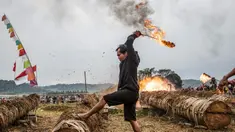 Seorang peserta menyalakan meriam yang terbuat dari batang pohon dengan menggunakan karbit dan air untuk menciptakan suara ledakan selama Festival Kuluwung, di Sukasirna, Jawa Barat, pada tanggal 5 April 2025. (ADITYA AJI/AFP)