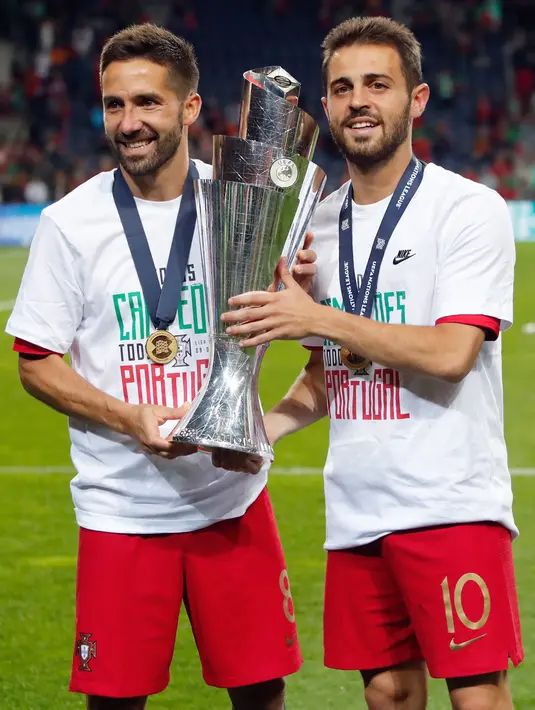 Gelandang Portugal, Joao Moutinho dan Bernardo Silva berpose dengan Piala UEFA Nations League setelah pertandingan final di Estadio do Dragao, Porto (10/6/2019). Portugal berhasil mengalahkan Belanda 1-0, berkat gol Goncalo Guedes. (AP Photo/Armando Franca)