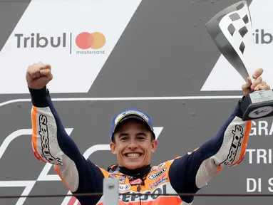 Pembalap Repsol Honda, Marc Marquez memegang trofi juara balapan MotoGP San Marino 2017 di atas podium Sirkuit Misano, Italia, Minggu (10/9). Marquez sukses mencatat waktu 50 menit 41,565 detik, terpaut 1,192 detik. (AP Photo/Antonio Calanni)