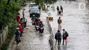 Pengendara dan pejalan kaki melewati perempatan Green Garden, Kedoya, Jakarta, Jumat (3/1/2020). Hingga hari ke-3, banjir masih menggenangi sekitar kawasan perempatan Green Garden, Kedoya akibatnya pengendara harus lebih waspada menghindari mesin kemasukan air. (Liputan6.com/Helmi Fithriansyah)