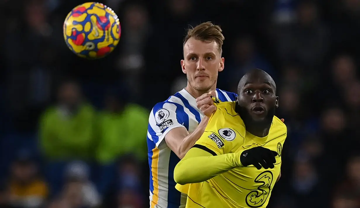 Pemain Brighton and Hove Albion Dan Burn (kiri) berebut bol dengan pemain Chelsea Romelu Lukaku (kanan) pada pertandingan sepak bola Liga Inggris di American Express Community Stadium, Brighton, Inggris, 18 Januari 2022. Pertandingan berakhir 1-1. (Glyn KIRK/AFP)