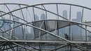 Warga melintasi jembatan penyeberangan saat kabut asap menyelimuti Singapura, Rabu (18/9/2019). Kebakaran hutan Indonesia menyebarkan kabut asap hingga Singapura dan Malaysia. BMKG mendeteksi sebaran asap akibat kebakaran hutan dan lahan di Sumatra mencapai Singapura dan Malaysia. (Mohd RASFAN/AFP)