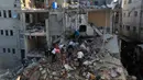 <p>Warga Palestina memeriksa kerusakan di sekitar bangunan tempat tinggal setelah serangan udara Israel di kamp pengungsi Rafah di Jalur Gaza Selatan pada 1 Desember 2023, (SAID KHATIB/AFP)</p>