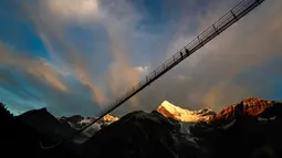 Pengunjung berjalan di jembatan gantung yang baru diresmikan di Zermatt, Swiss, 29 Juli 2017. Dewan Pariwisata Zermatt mengatakan jembatan ini merupakan yang terpanjang mengungguli jembatan serupa di Reutte, Austria. (Valentin Flauraud/Keystone via AP)