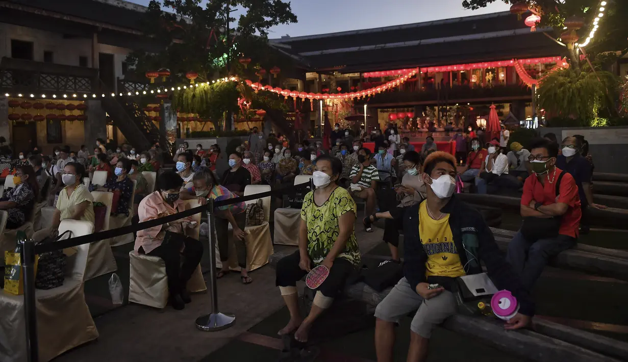Orang-orang menonton saat rombongan Opera tradisional China, Sai Yong Hong melakukan pertunjukan untuk merayakan Tahun Baru Imlek yang akan datang, di gudang Lhong 1919 di Bangkok (19/1/2022). (AFP/Lillian Suwanrumpha)