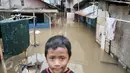 Seorang anak berada di kawasan Cawang, Jakarta, Selasa (21/2). Akibat curah hujan yang tinggi sejumlah pemukiman di bantaran Ciliwung kelurahan Cawang dan Rawajati terendam banjir. (Liputan6.com/Yoppy Renato)