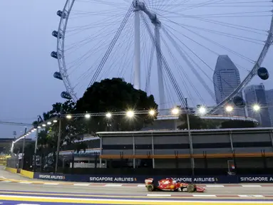 Pembalap Ferrari Formula 1, Sebastian Vettel saat melakukan sesi latihan jelang Grand Prix Singapura F1 di Sirkuit Marina Bay (18/9/2015). Kabut asap yang menyelimuti sirkuit tak menyurutkan pembalap untuk tetap melakukan pemanasan. (REUTERS/Tim Chong)