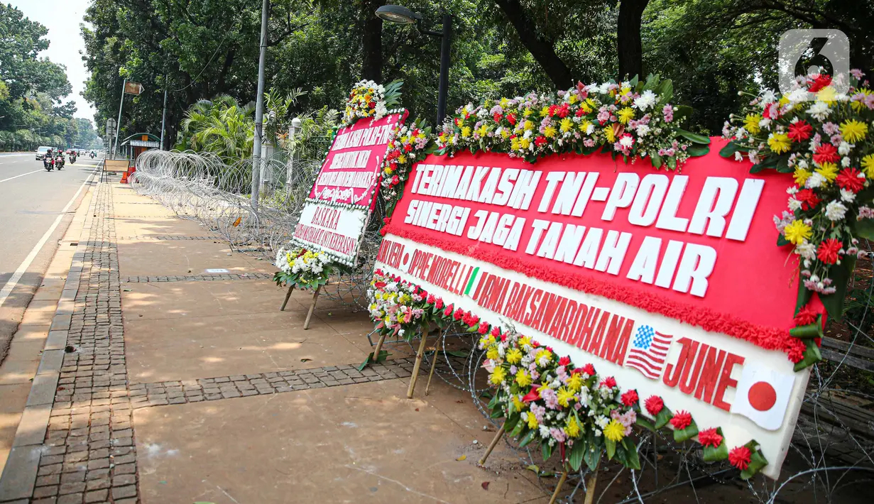 Sejumlah karangan bunga menghiasi kawasan Patung Kuda, Jakarta, Kamis (15/10/2020). Karangan bunga tersebut merupakan apresiasi masyarakat kepada TNI-Polri yang telah menjaga keamanan saat demo. (Liputan6.com/Faizal Fanani)
