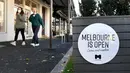 Orang-orang berjalan melewati tanda di kafe dan restoran Lygon Street di Melbourne, Rabu (2/6/2021). Kota Melbourne dan wilayah lainnya di negara bagian Victoria, Australia, akan mengalami perpanjangan lockdown yang tadinya dijadwalkan berakhir pada Kamis (3/6/2021) malam. (William WEST / AFP)