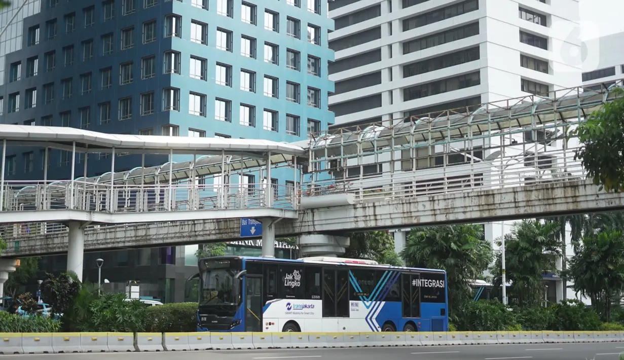 Bus Transjakarta melintas di dekat JPO yang juga akses menuju Halte Transjakarta Karet di Jakarta, Kamis (12/11/2020). Pemprov DKI Jakarta akan merevitalisasi jembatan penyeberangan orang (JPO) di Jalan Sudirman, Jakarta Pusat, tepatnya di depan Hotel Le Meridien. (Liputan6.com/Immanuel Antonius)
