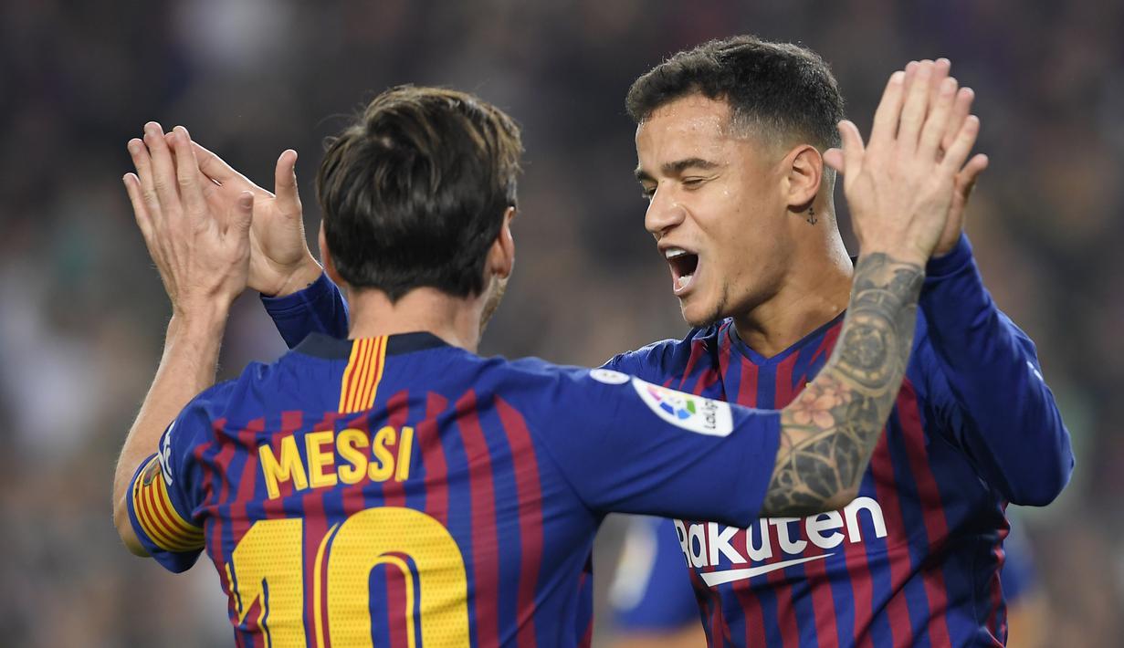 Pemain Barcelona, Philippe Coutinho, merayakan gol yang dicetak Lionel Messi ke gawang Sevilla pada laga La Liga Spanyol di Stadion Camp Nou, Barcelona, Sabtu (20/10). Barcelona menang 4-2 atas Sevilla. (AFP/Lluis Gene)
