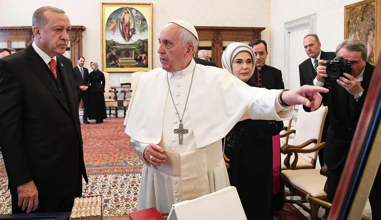 Presiden Turki Erdogan menyimak pembicaraan dari Paus Fransiskus saat kunjungannya ke Vatikan (5/2).  Pertemuan itu juga membahas perkembangan di Timur Tengah, khususnya Suriah, terorisme serta dialog antar-agama. (Alessandro Di Meo / Pool via AP)