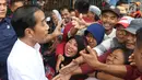 Presiden Joko Widodo atau Jokowi menyapa warga saat blusukan di Pasar Minggu, Jakarta, Jumat (22/2). Jokowi berada di Pasar Minggu hanya sekitar 20 menit. (Liputan6.com/Angga Yuniar)