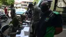 Petugas Satpol PP mendata warga yang terjaring razia pelanggar PSBB (Pembatasan Sosial Berskala Besar) di Pasar Gembrong, Jakarta, Selasa (2/6/2020). Para pelanggar aturan PSBB tersebut dijatuhi sanksi membayar denda atau melakukan pelayanan sosial. (merdeka.com/Imam Buhori)