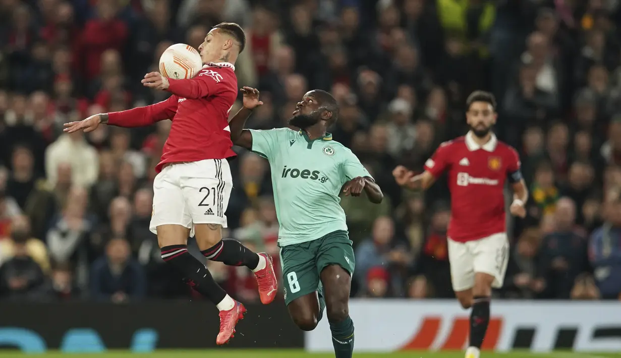 Penyerang Manchester United atau MU, Antony mengontrol bola saat gelandang Omonia Nicosia, Moreto Cassama mencoba menghentikannya dalam laga matchday 4 fase grup Liga Europa 2022/2023 di Old Trafford, Jumat dini hari WIB (14/10/2022). Scott McTominay menjadi pahlawan MU dengan golnya di injury time. (AP Photo/Dave Thompson)