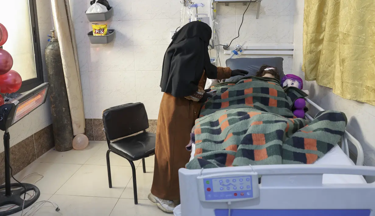 Gadis Suriah Sham Sheikh Mohammad (9) yang diselamatkan setelah empat puluh jam di bawah reruntuhan gempa Turki-Suriah yang mematikan, terbaring di ranjang rumah sakit di provinsi Idlib yang dikuasai pemberontak, pada 17 Februari 2023. Seorang gadis yang menjadi simbol harapan di tengah tragedi ketika tim penyelamat menariknya dari bawah puing-puing di barat laut Suriah yang dilanda gempa sekarang berisiko diamputasi kedua kakinya. (Omar HAJ KADOUR / AFP)